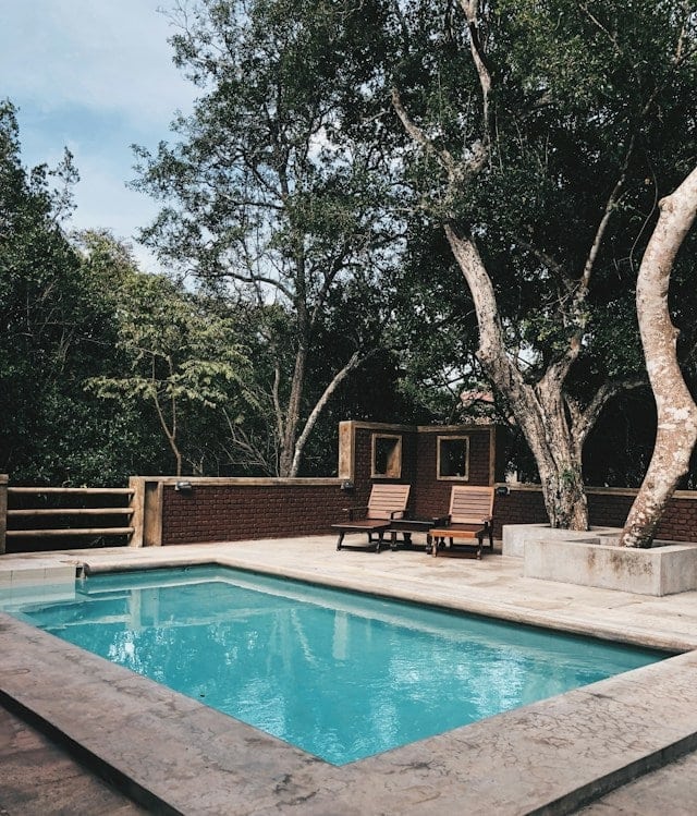 Two lounge chairs near swimming pool Two lounge chairs near swimming pool