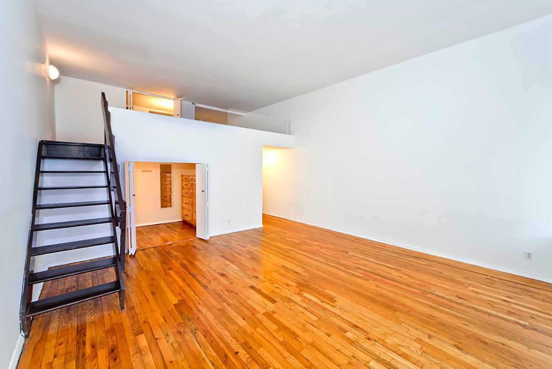 Before photo of a small loft apartment interior.