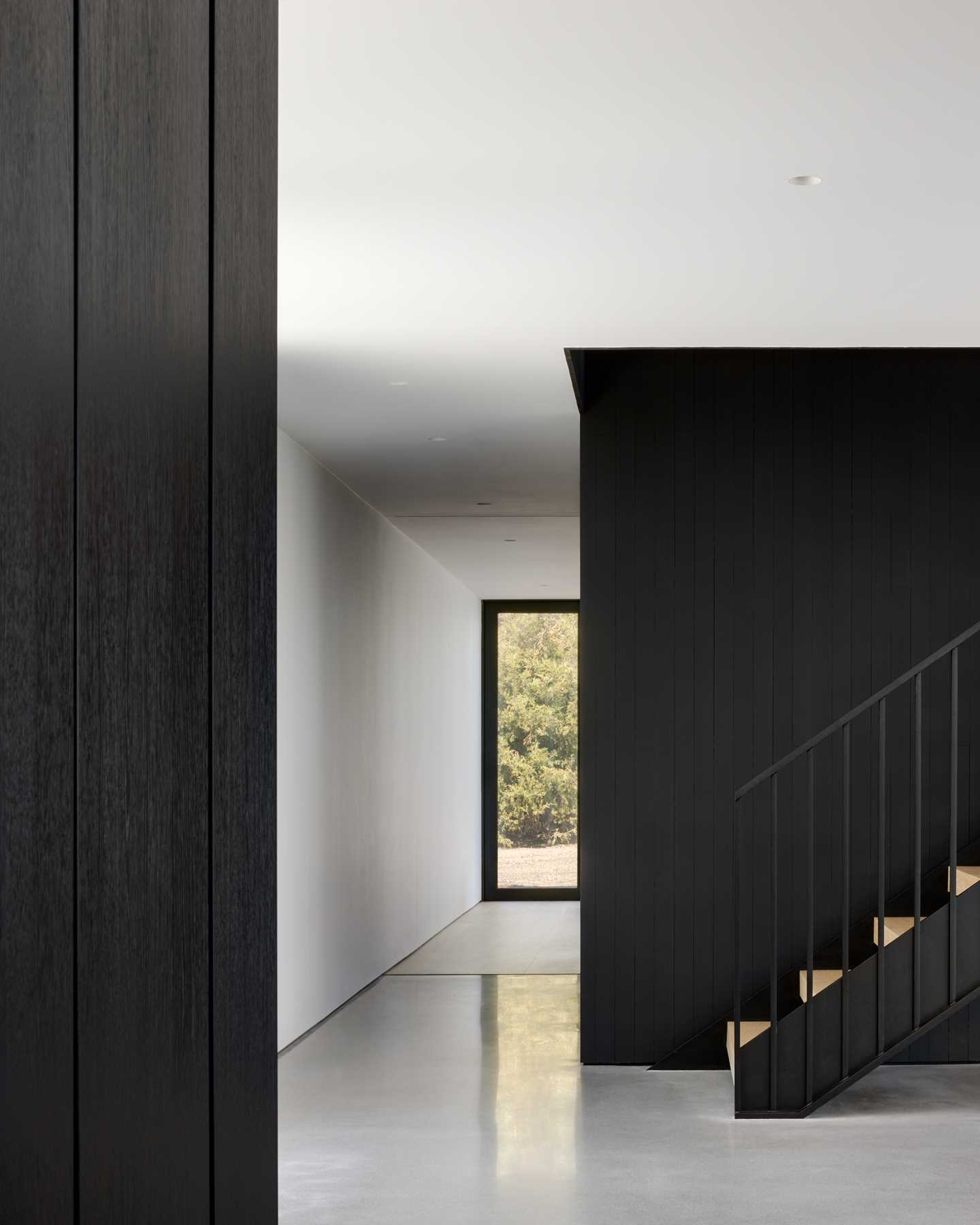 A floating staircase and cedar-clad volume define the separation between public and private spaces in this home.