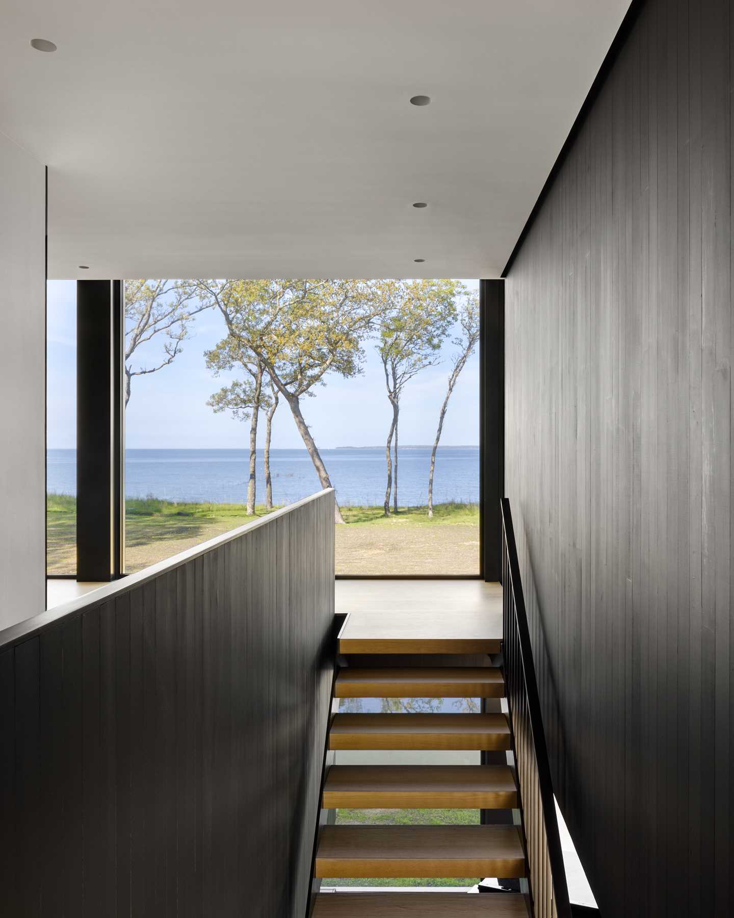 A floating staircase and cedar-clad volume define the separation between public and private spaces in this home.