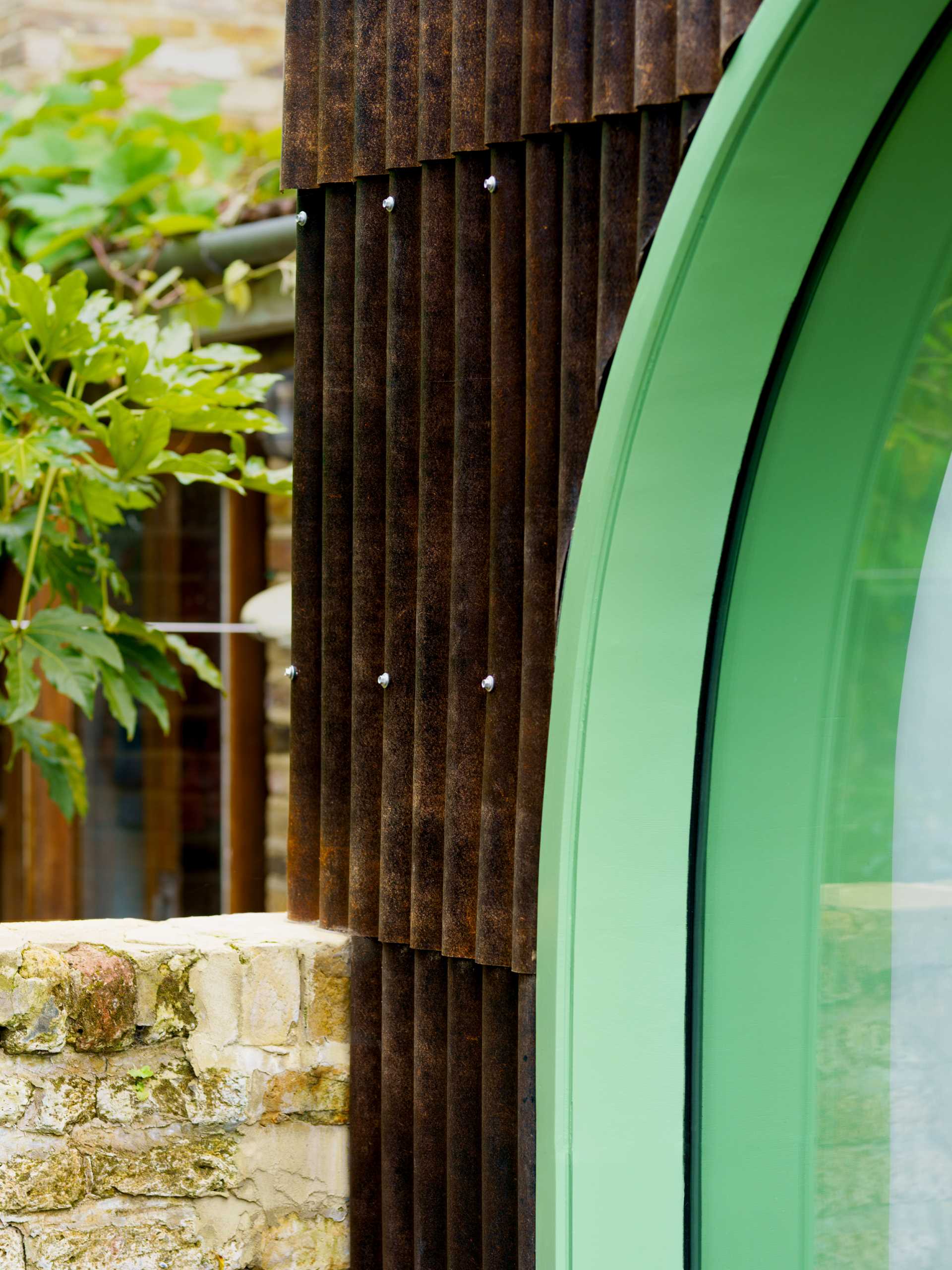 A modern home extension with a curved window, a skylight, and a new dining area and custom kitchen with IKEA cabinets.