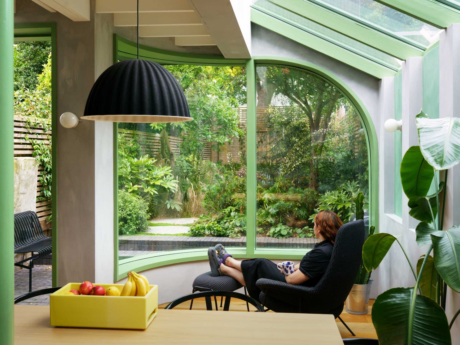 A modern home extension with a curved window, a skylight, and a new dining area and custom kitchen with IKEA cabinets.