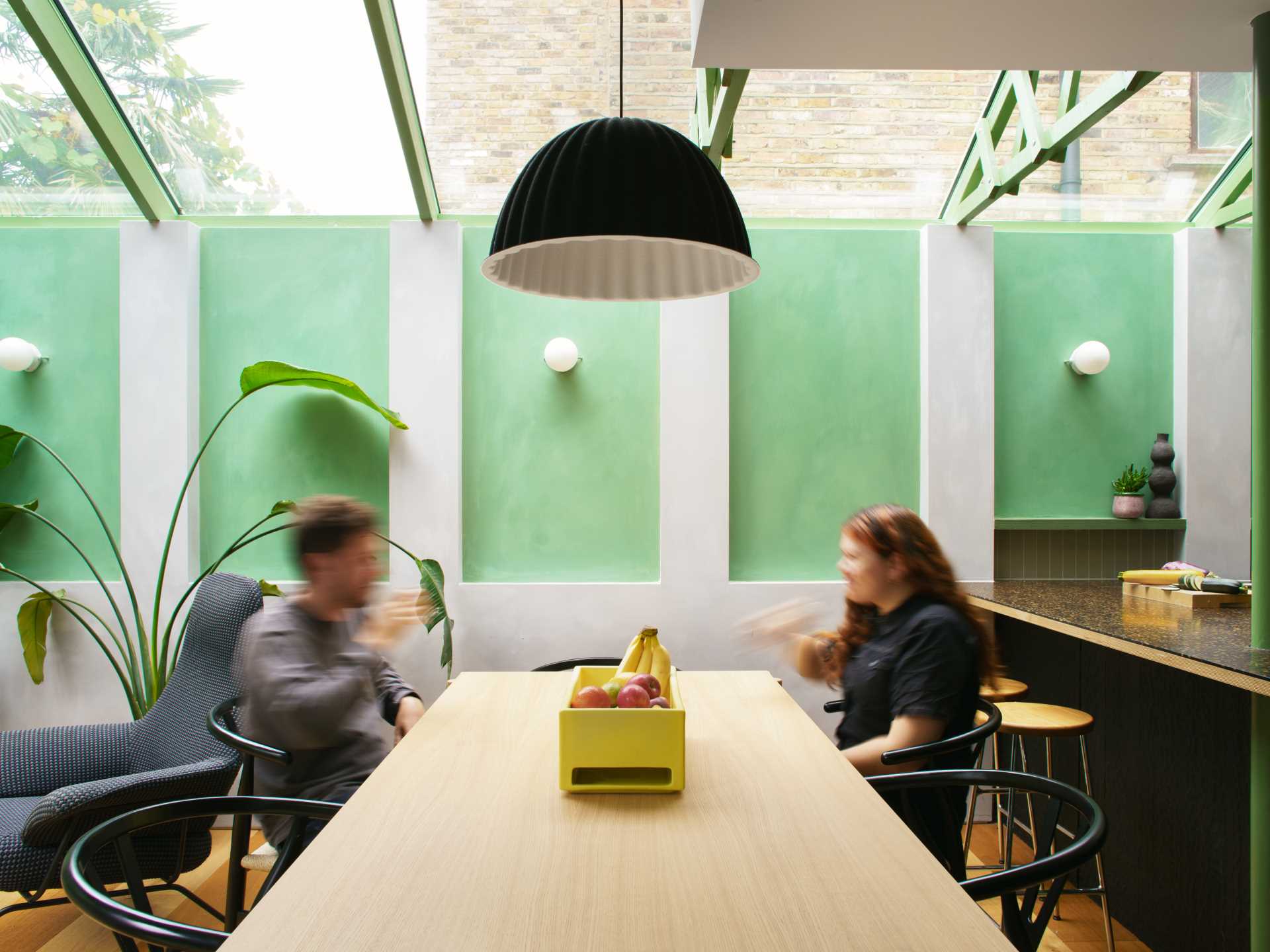 A modern home extension with a curved window, a skylight, and a new dining area and custom kitchen with IKEA cabinets.