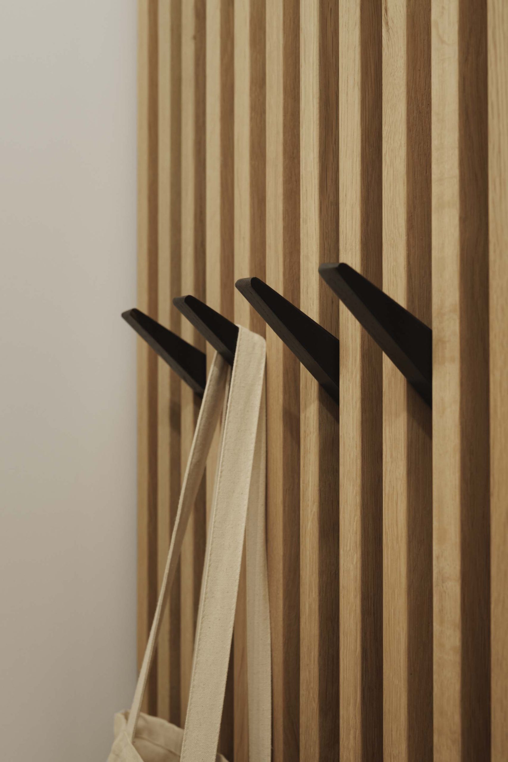 The slat wall continues in the bathroom, where it's been paired with striated slate gray and glass.