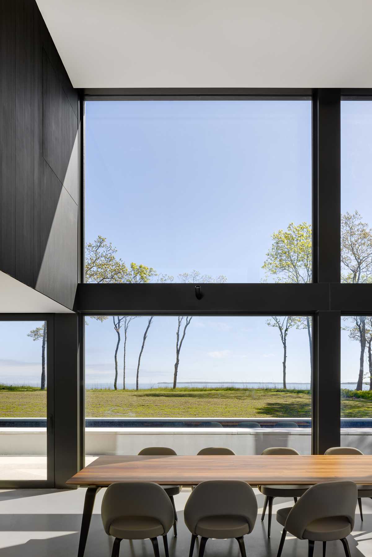 A modern open-plan dining area with large windows.