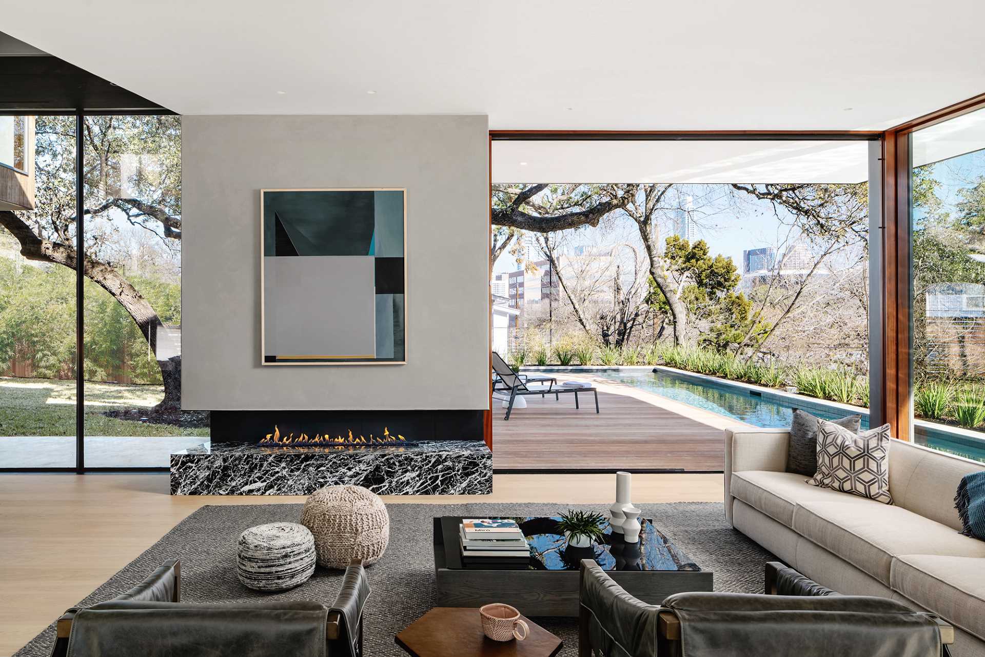 This modern living room with its fireplace, opens up to the deck, and has views of the city in the distance.